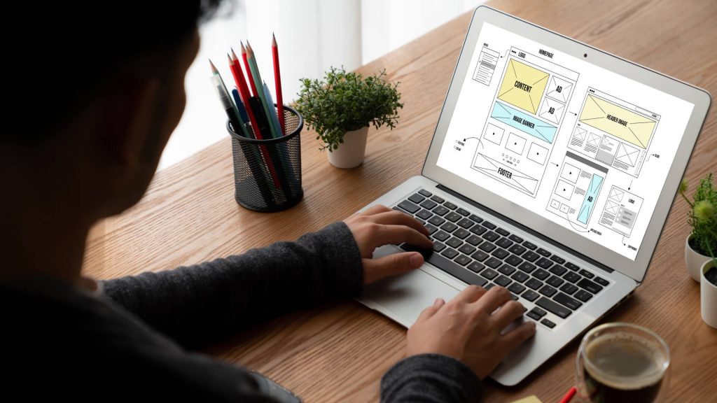 A person working on a web design mockup on a laptop, illustrating the web design process and the importance of professional services.
